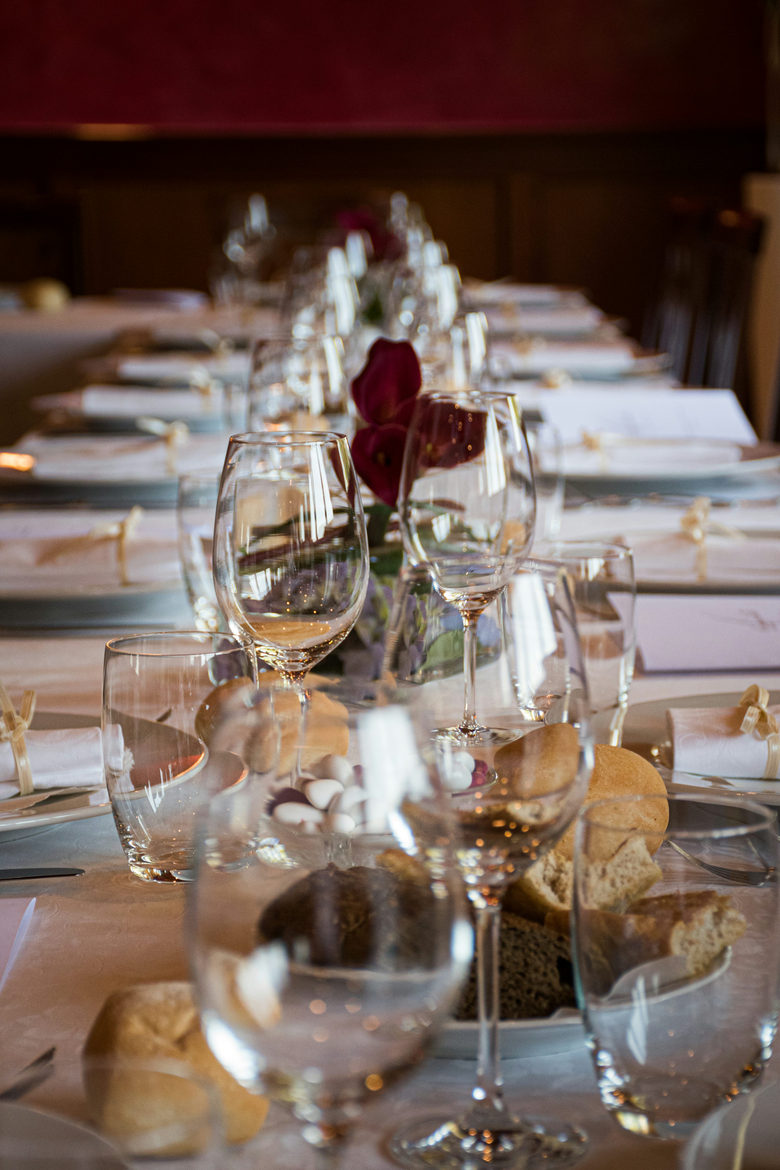 Long formal dinner table with multiple wine glasses set for a dinner party