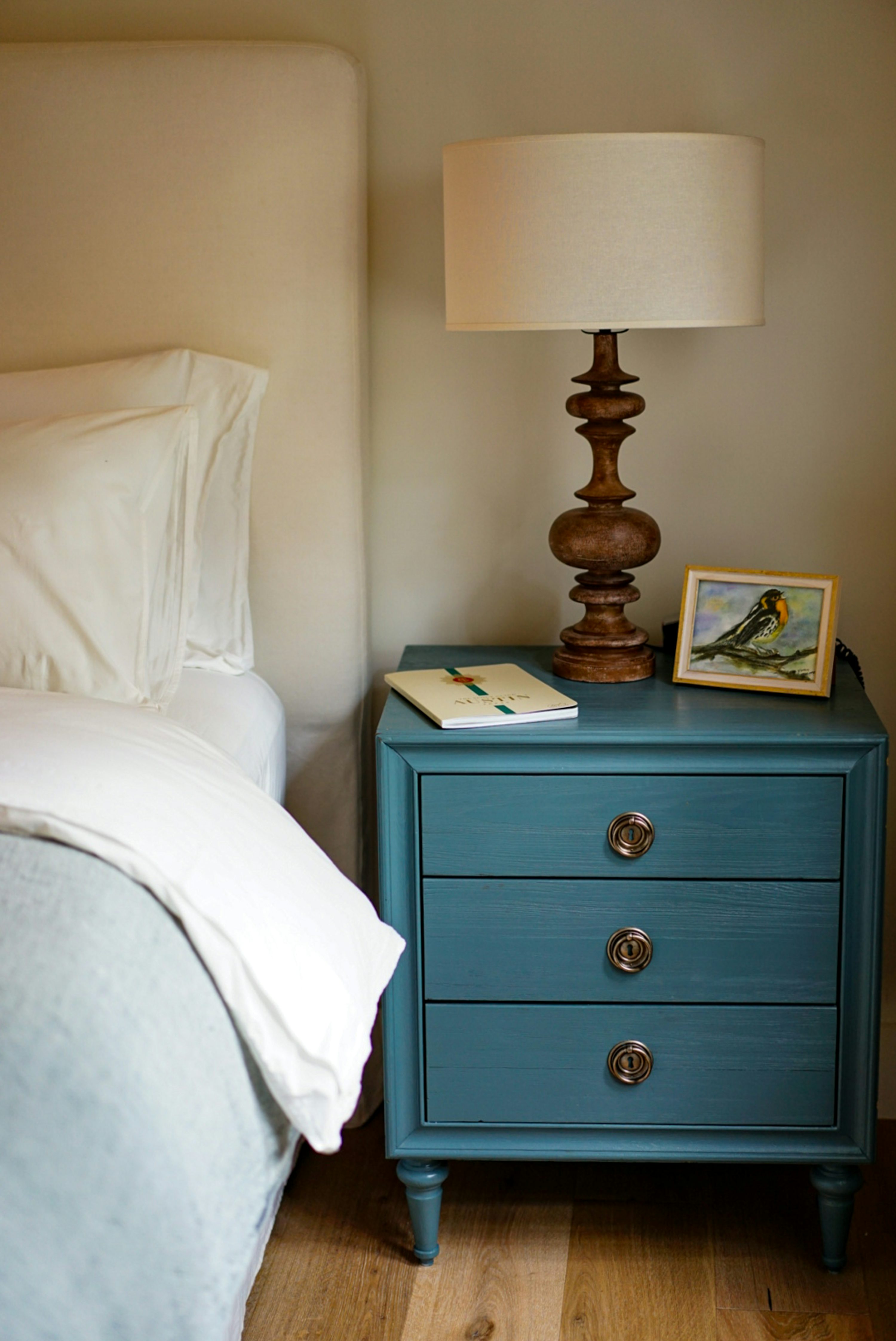 Cozy bedroom nightstand with lamp, book, and small framed art