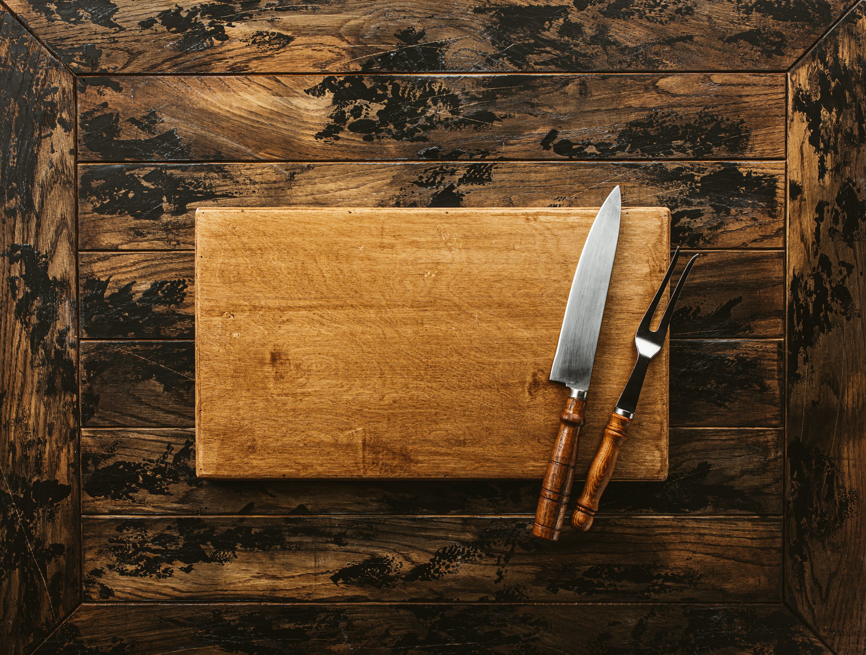 Kitchen knife and cutting board on rustic wood surface