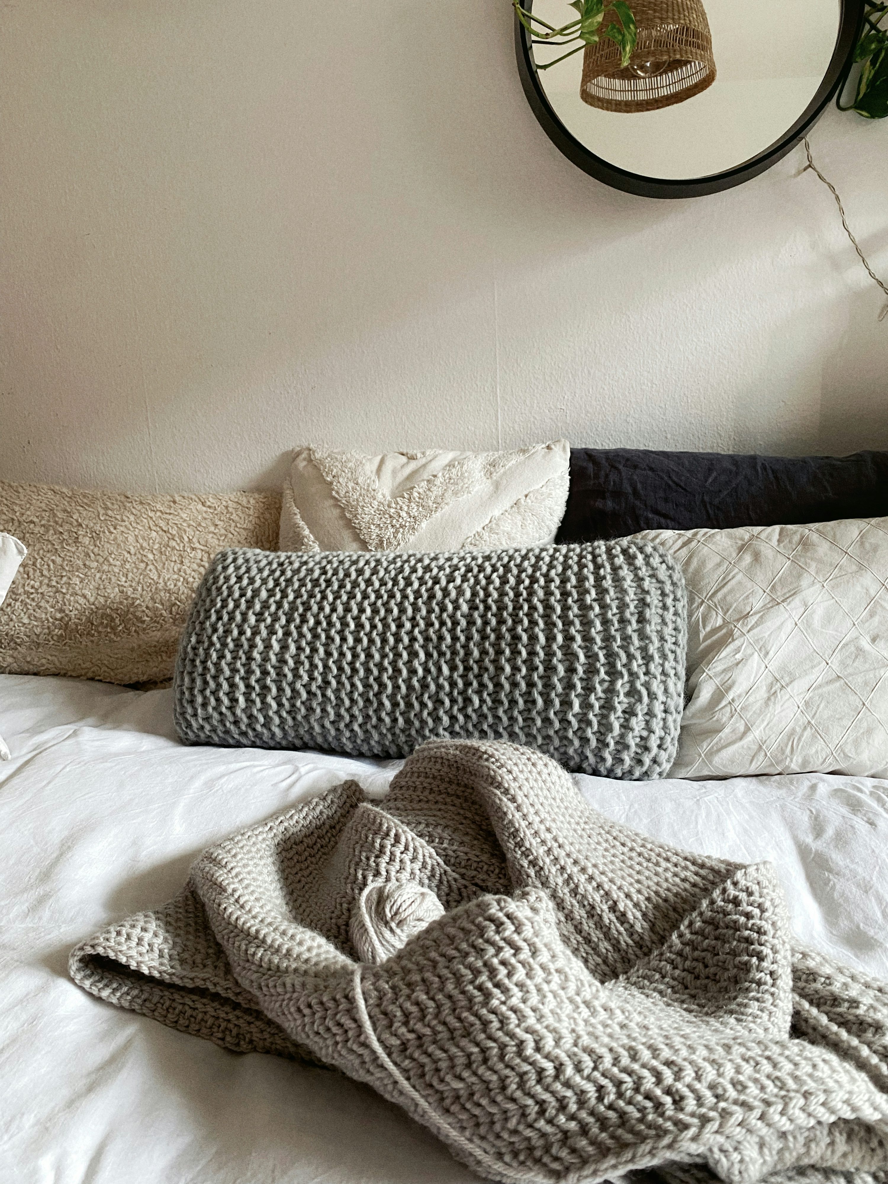 Cozy bedroom with knitted throw blankets on a bed